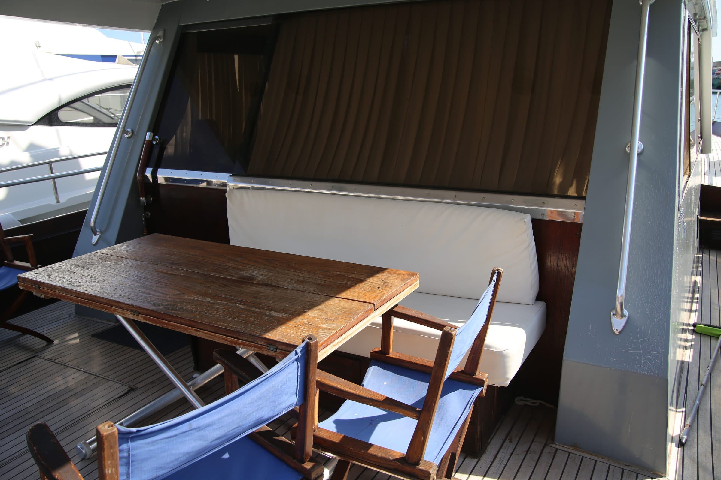 The shaded cockpit of Antonella IV, with its teak table and blue director's chairs