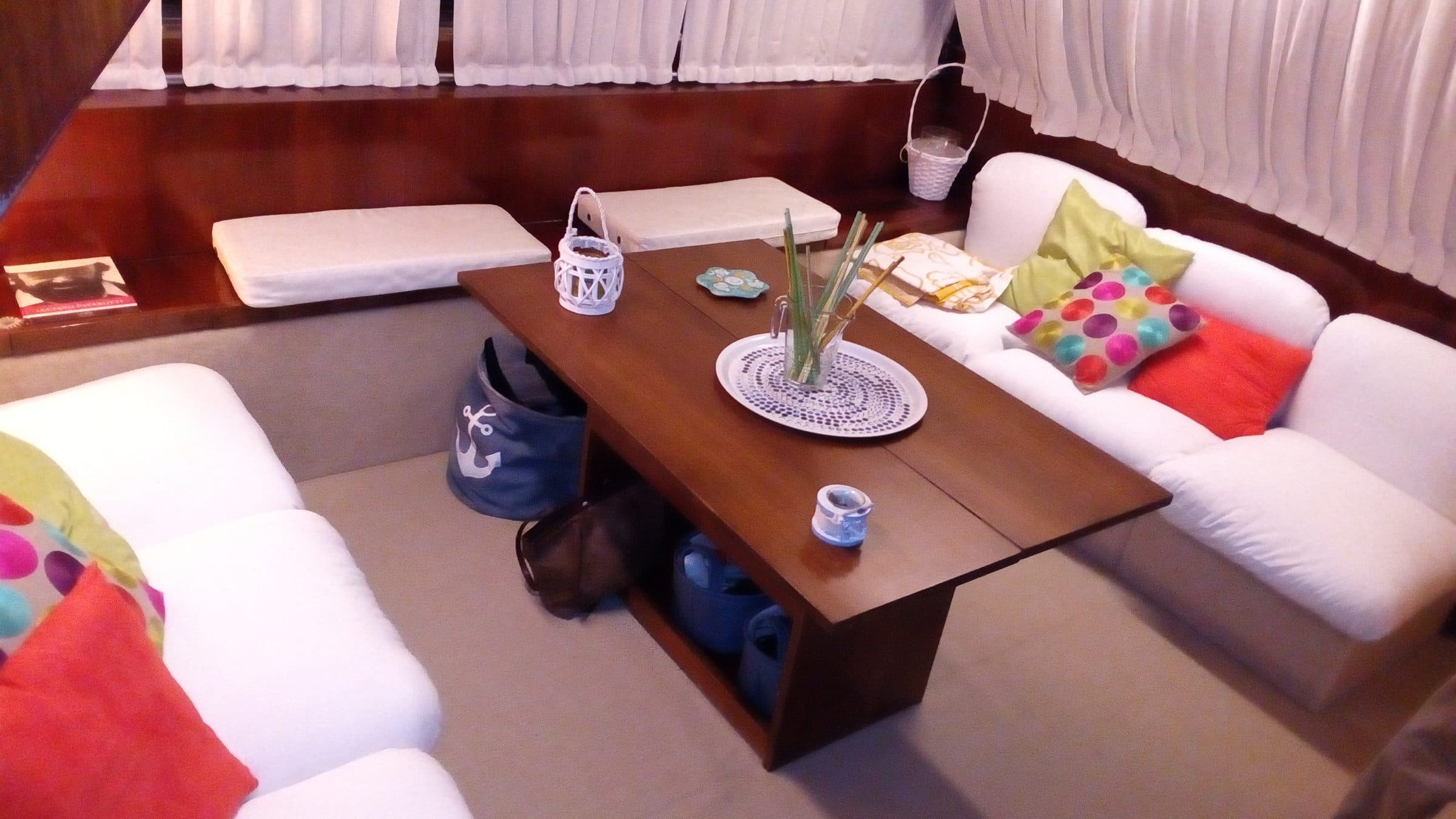 The saloon of Antonella IV, with white sofas around a wooden table