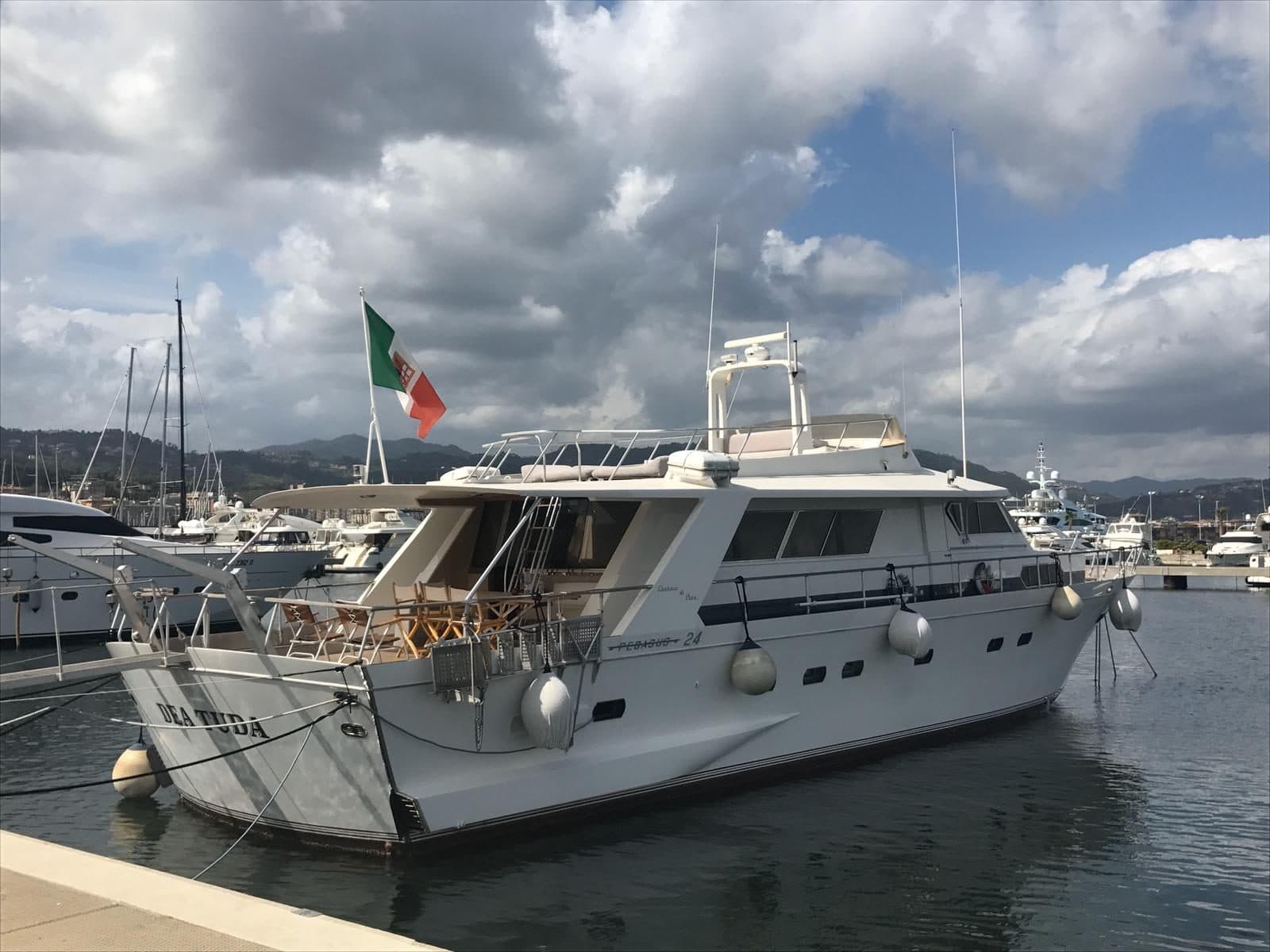 Dea Tuda moored in the marina, flying the Italian flag